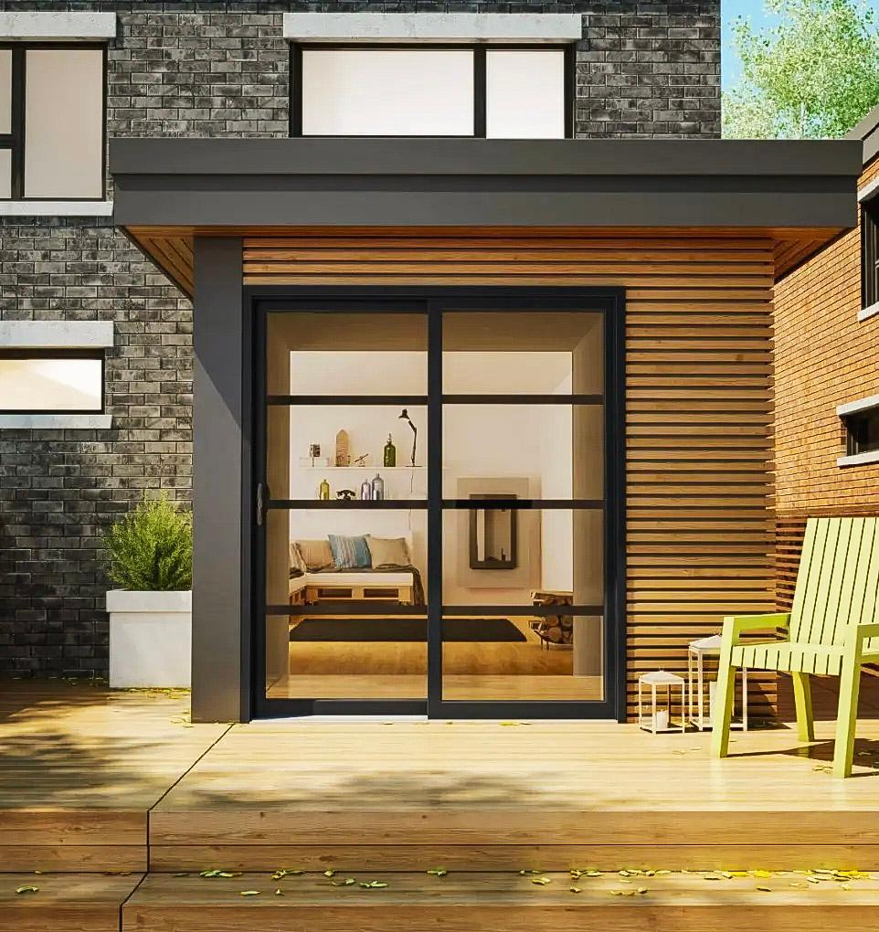 Façade moderne d'une maison contemporaine avec baie vitrée noire, bardage en bois et terrasse aménagée.