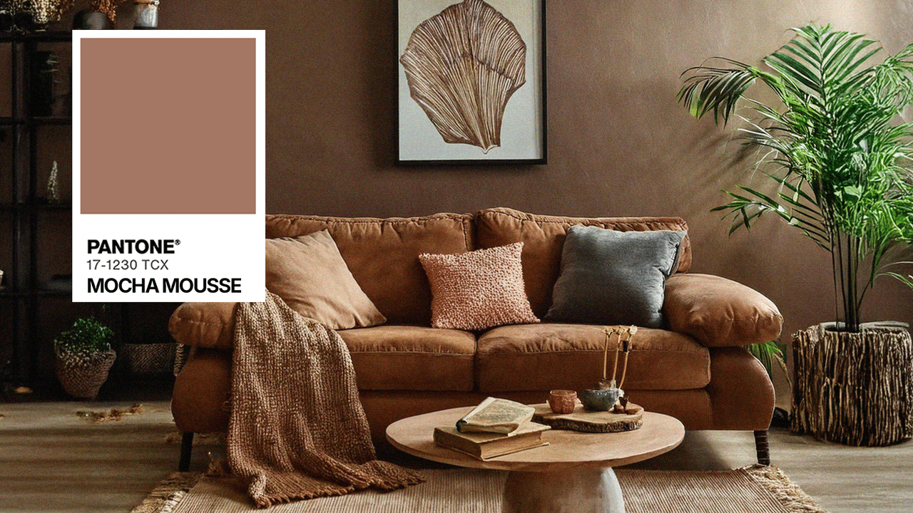 Salon chaleureux avec canapé en velours brun, mur couleur mocha mousse, décoration naturelle avec plante verte, coussins texturés et table basse en bois rond.