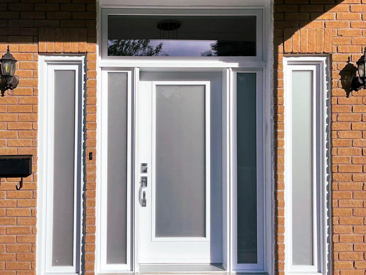 Porte d'entrée blanche avec verre givré et cadre en PVC dans une maison en brique.