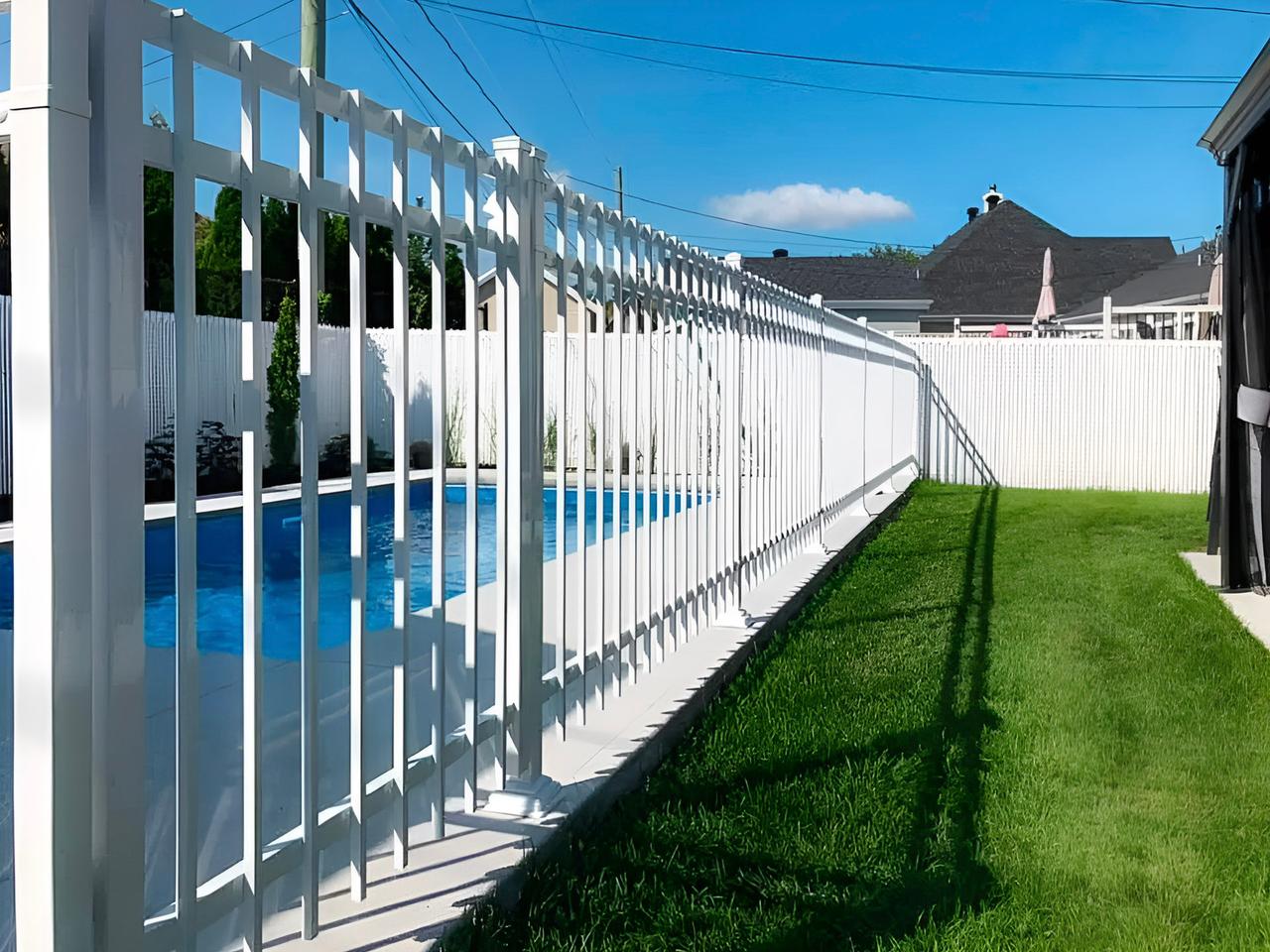 Clôture de sécurité blanche entourant une piscine résidentielle dans une cour arrière